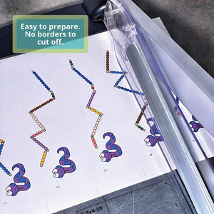 Sheet of JRMontessori snake game cards with cutting lines, being cut in a guillotine style paper cutter for easy prep